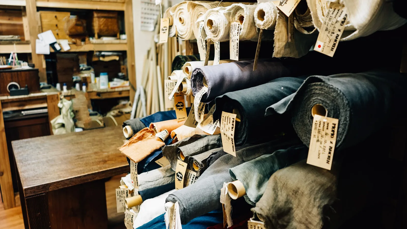Rolls of fabric stacked on workshop shelves